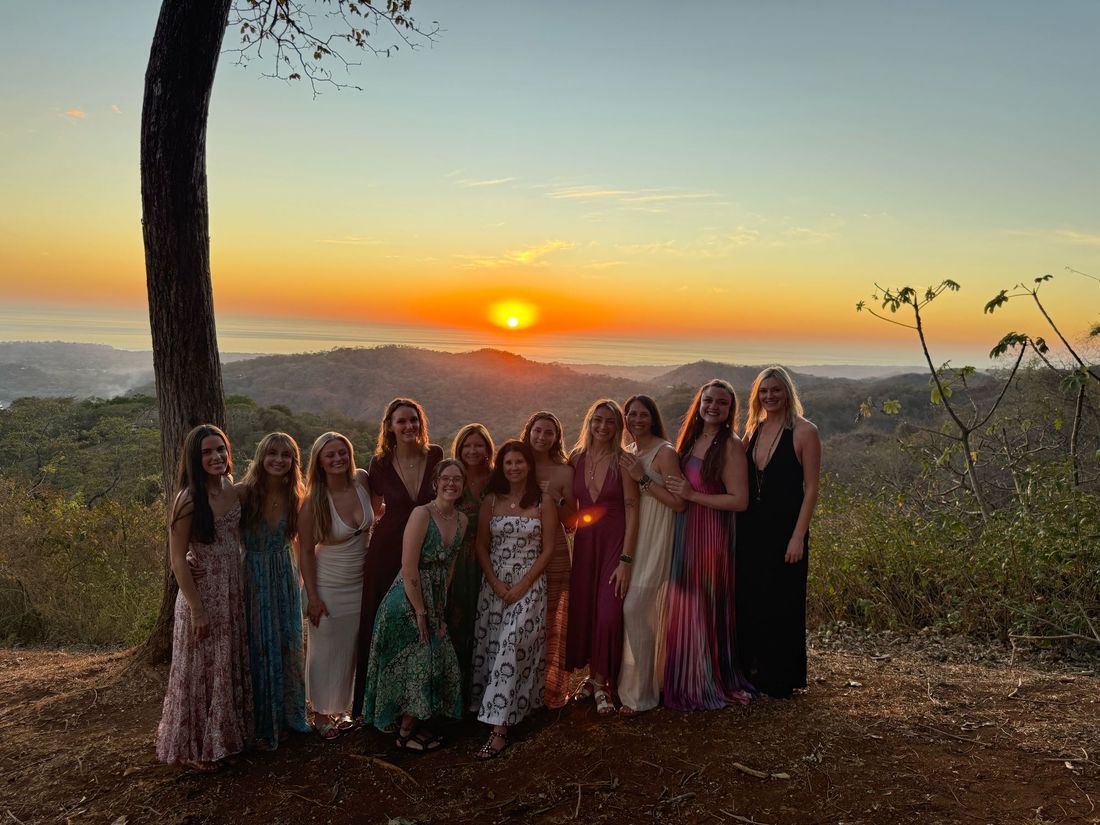 The 2026 group gathered on a hilltop as the sun sets over the Nosara hills