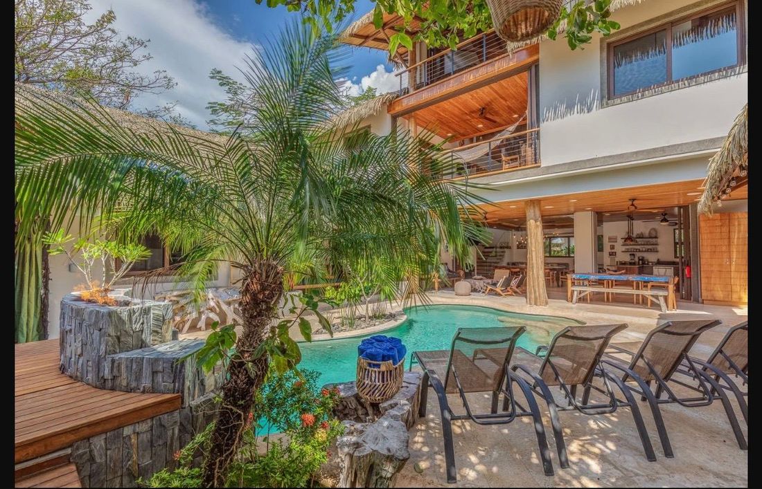 The saltwater lagoon pool, loungers and palms below the villa’s open terraces