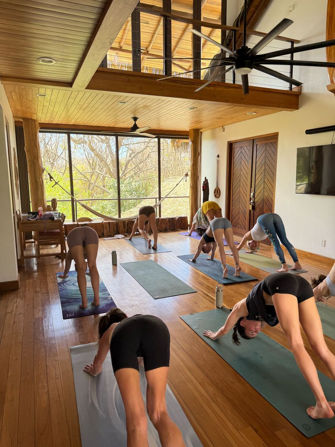 A group flowing through a yoga practice in the villa’s timber-framed great room